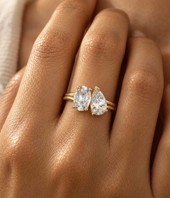 Oval and pear diamonds set side by side on a double yellow gold band.