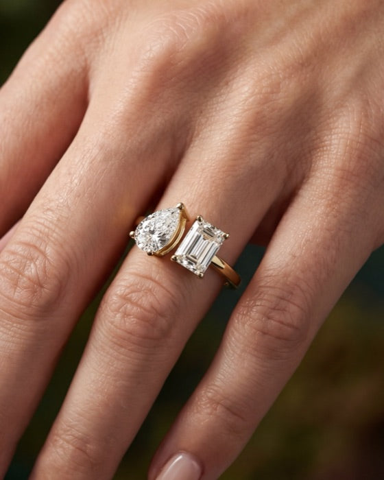 Vega pear and emerald engagement ring on the hand