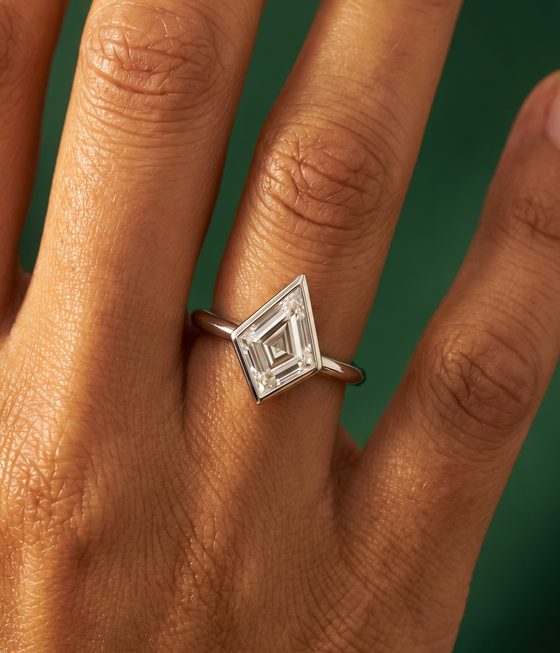 Kite-shaped step-cut diamond in a full bezel setting on a thin polished band.