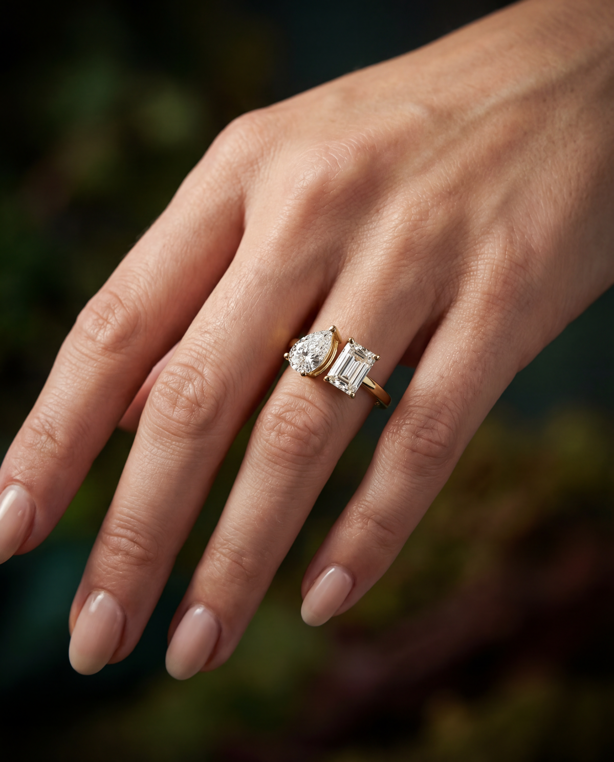 Vega pear and emerald toi-et-moi engagement ring worn on the hand