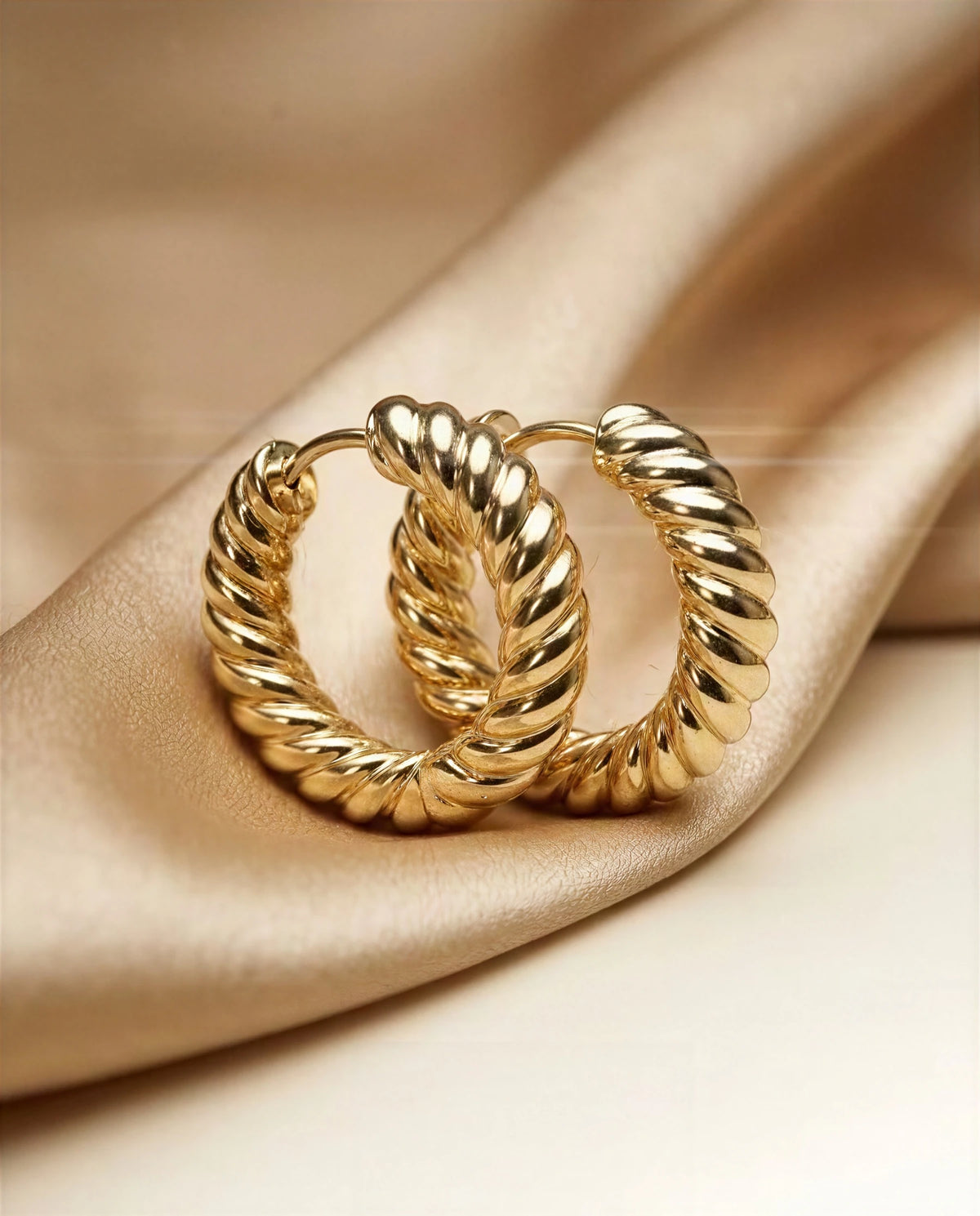 Marigold 14k gold ribbed croissant hoops on ivory satin