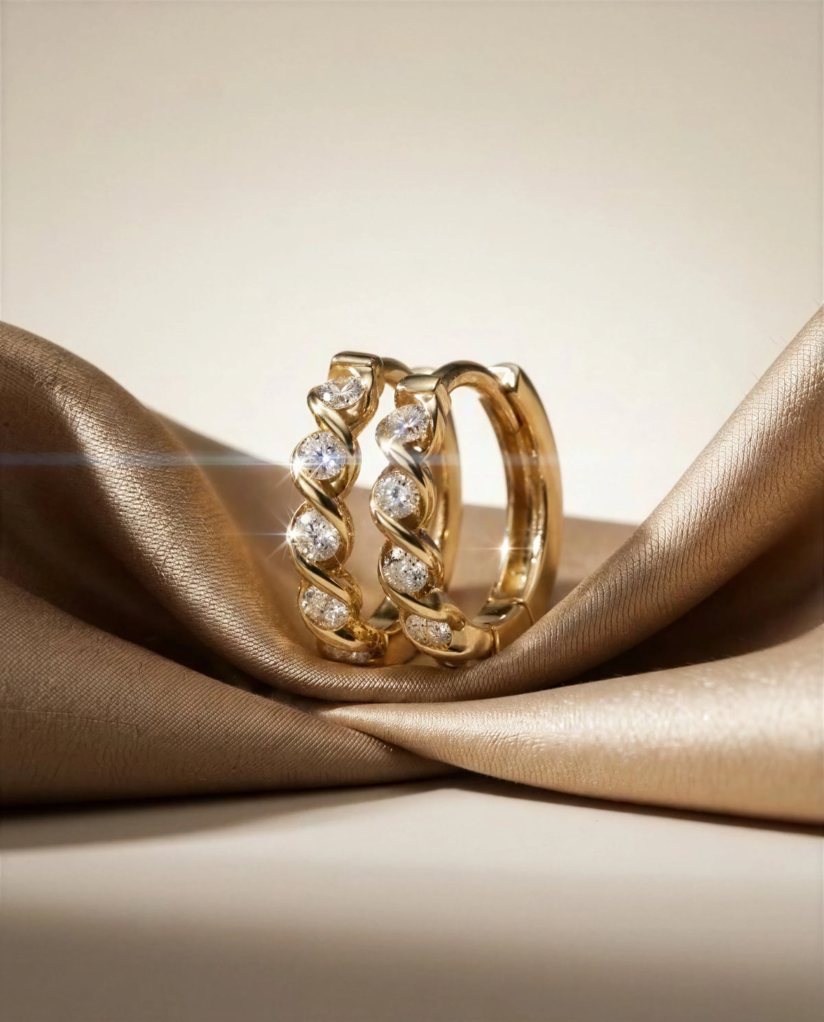 Spiranthes 14k gold diamond twist hoops on champagne satin