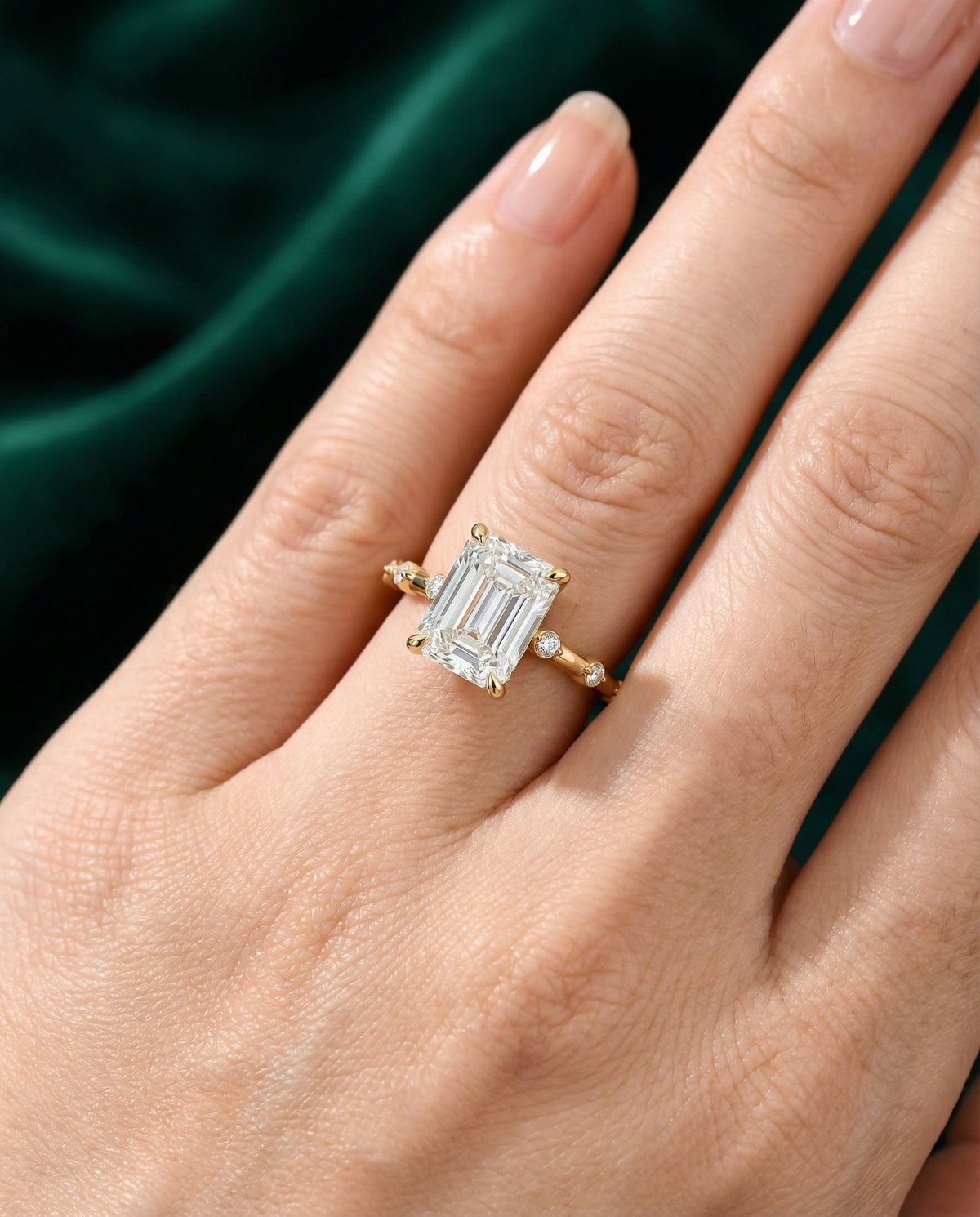 Lyra emerald engagement ring worn on the hand