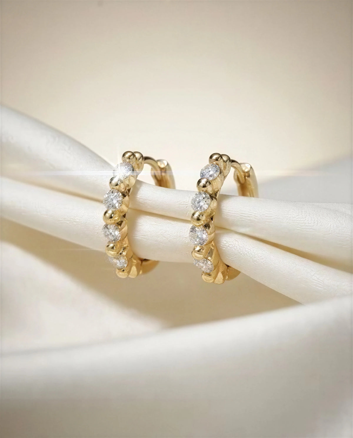Primrose 14k gold scalloped huggies on ivory satin