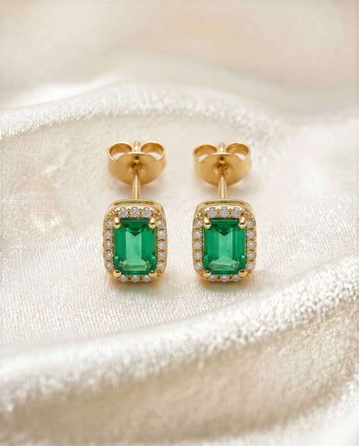 Cymbidium 14k gold emerald halo studs on soft ivory fabric