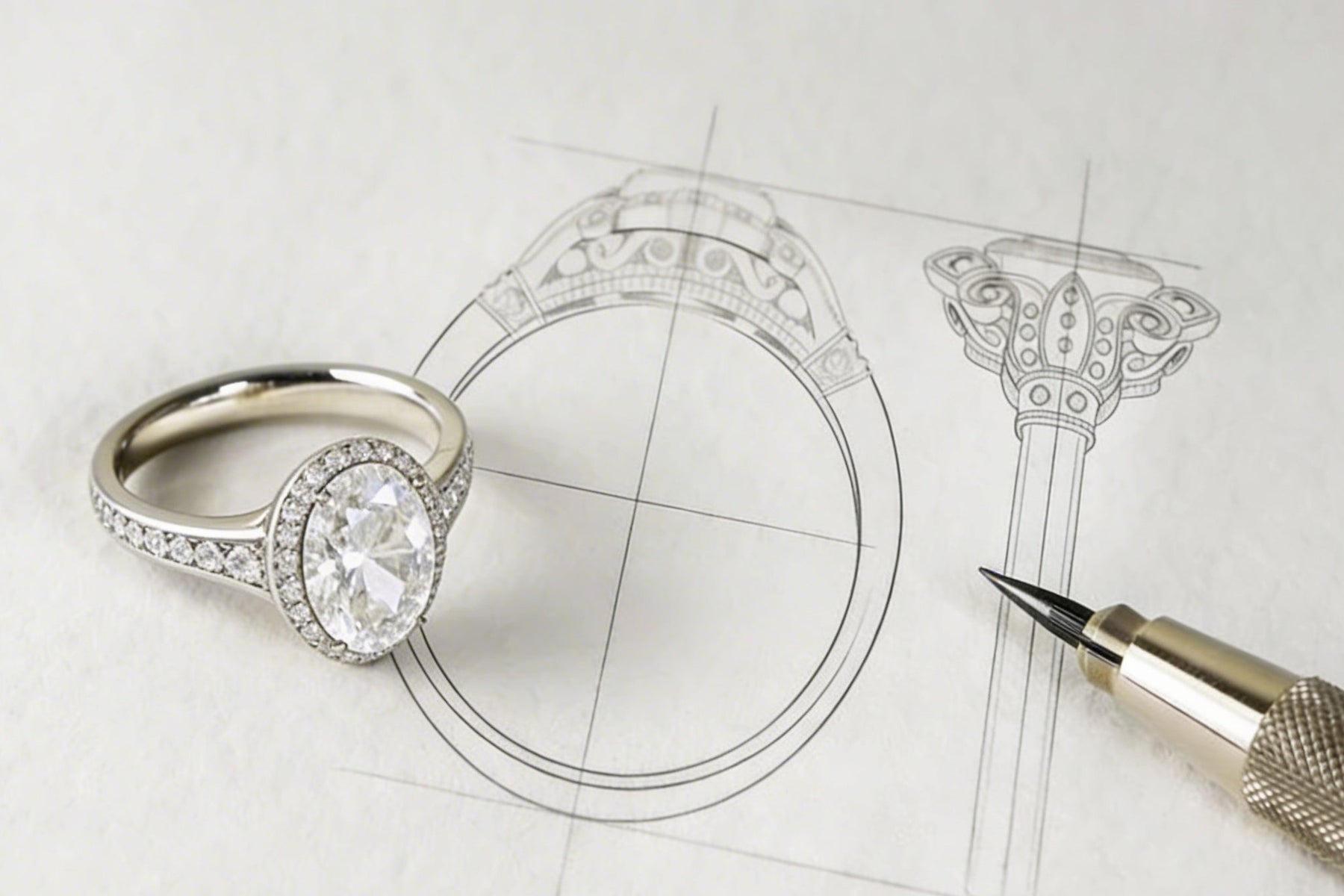 A diamond halo engagement ring resting on its pencil design drawing, beside a technical pen