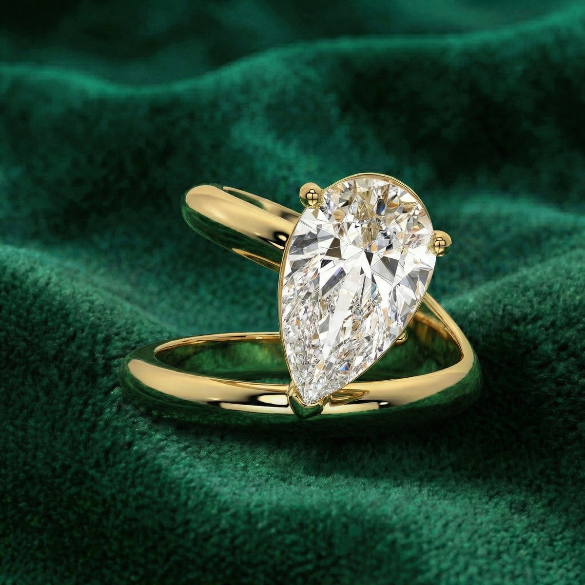 Eclipse pear engagement ring in yellow gold on green velvet