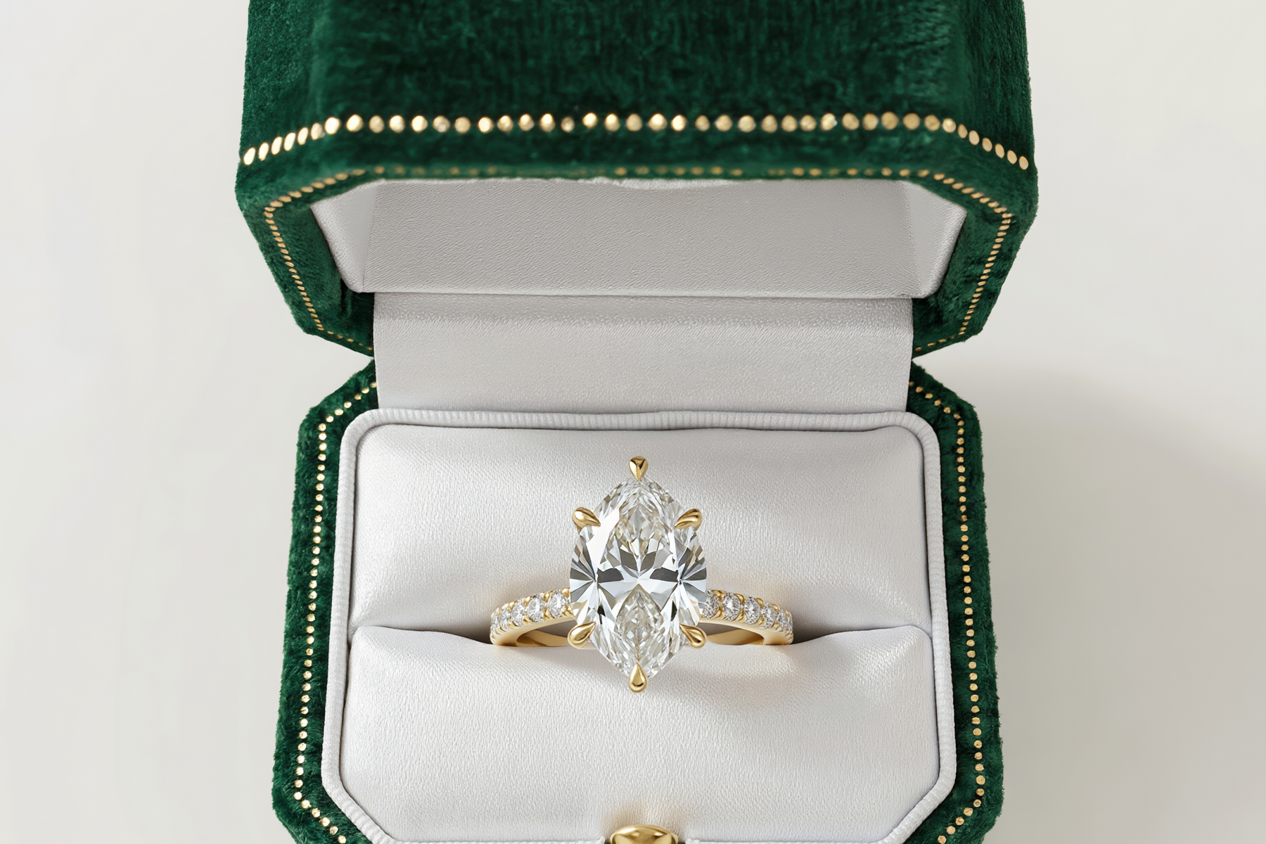 A marquise diamond engagement ring in an open green velvet ring box