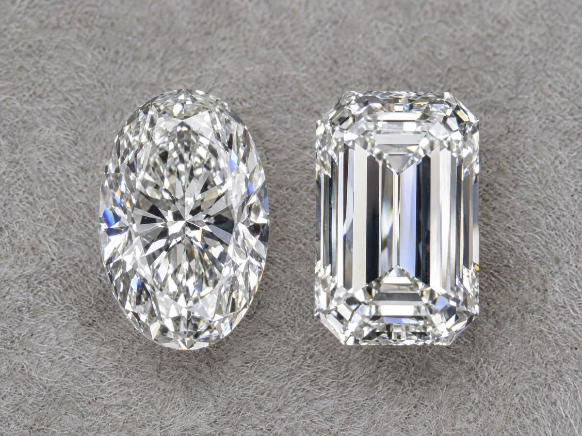 An oval diamond and an emerald cut diamond of the same carat weight side by side, face up