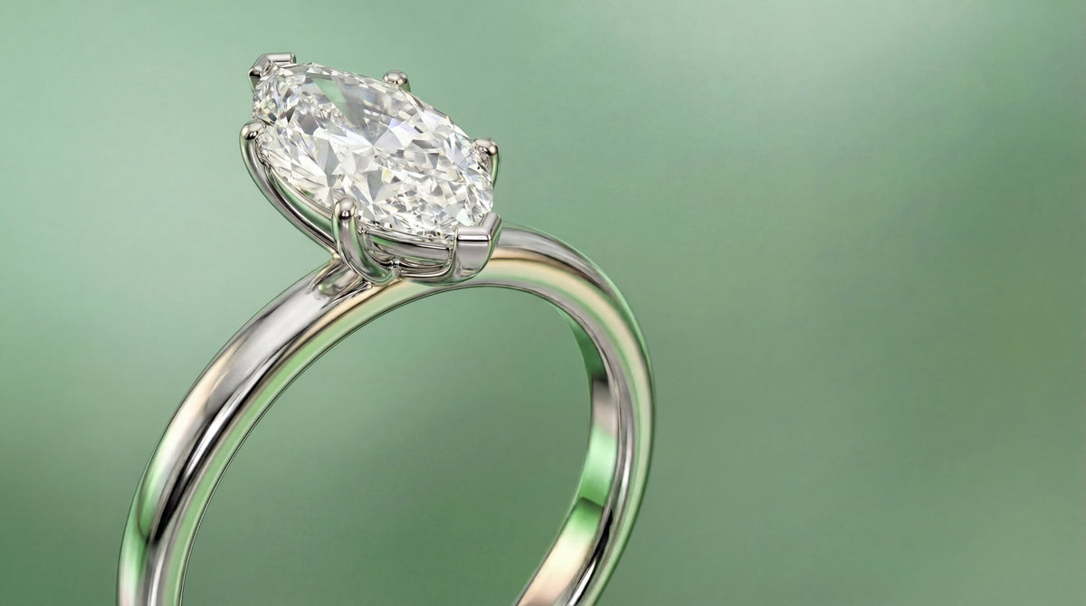 A marquise diamond solitaire in white gold, angled to show its prongs, head and band