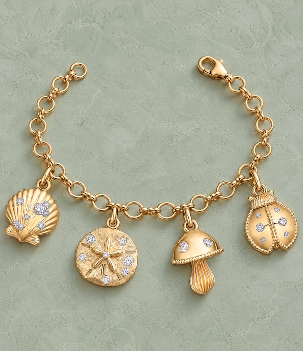 A gold charm bracelet with diamond-set scallop shell, sand dollar, mushroom and ladybug charms.