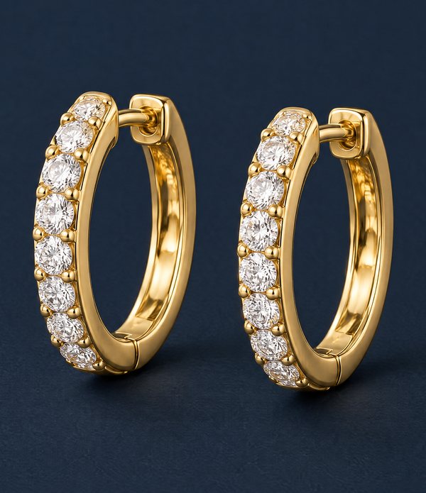 A pair of gold huggie hoop earrings set with a row of round diamonds.